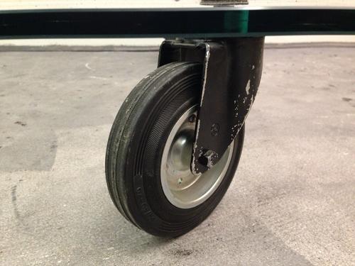 Low glass coffee table on industrial wheels