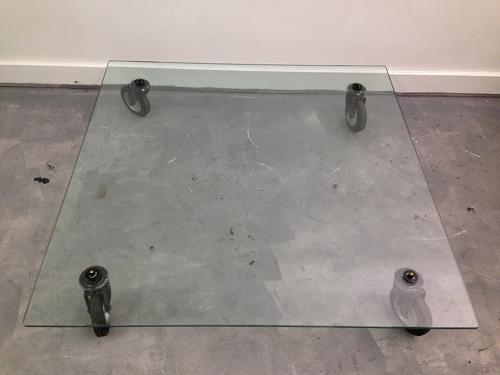 Low glass coffee table on industrial wheels