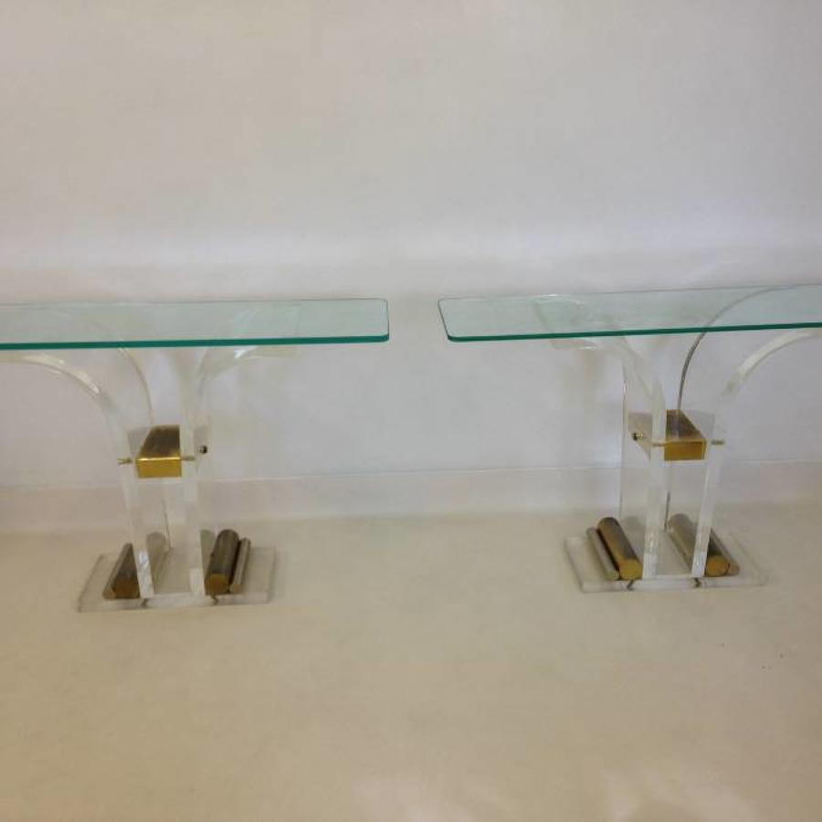 A pair of lucite and brass console tables