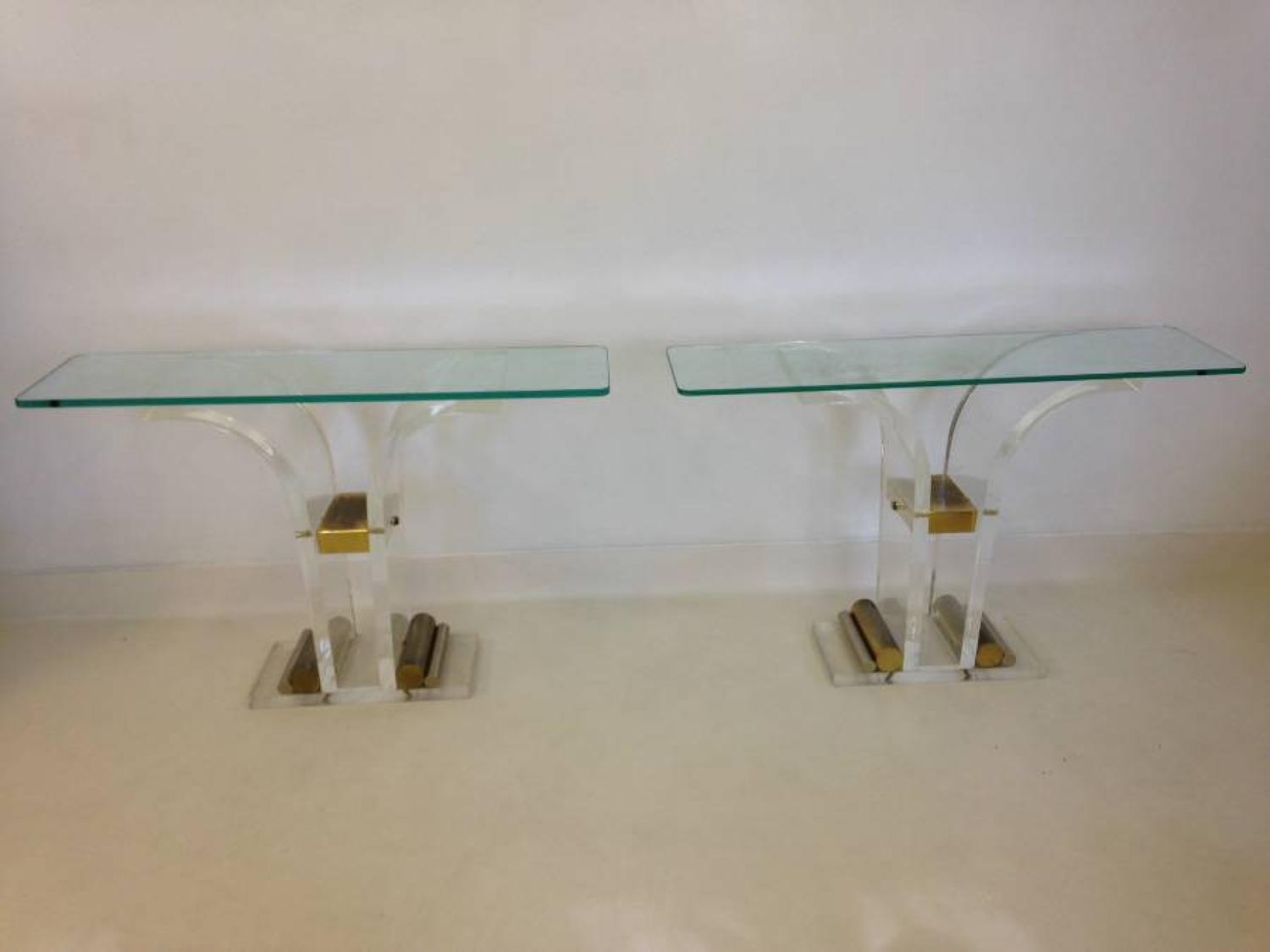 A pair of lucite and brass console tables