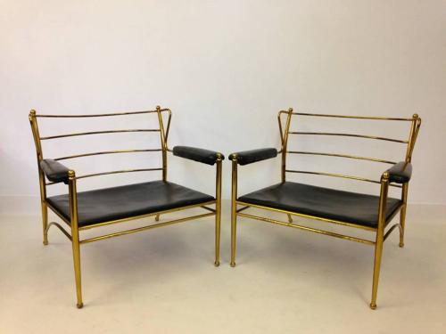 A pair of brass framed and leather armchairs