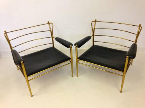 A pair of brass framed and leather armchairs