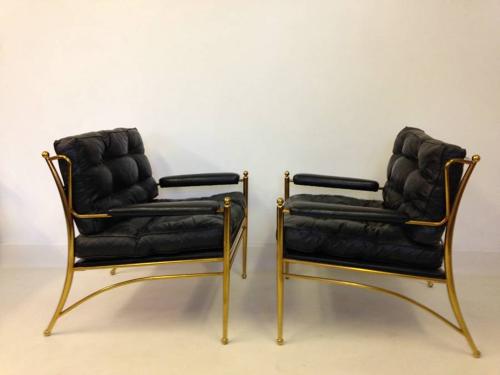 A pair of brass framed and leather armchairs