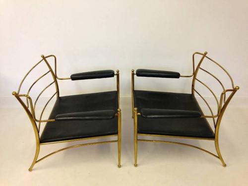 A pair of brass framed and leather armchairs