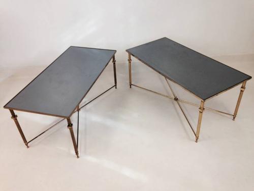 A pair of brass and black glass coffee tables