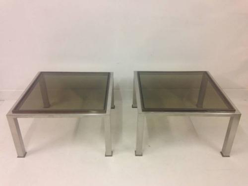 A pair of chrome and brass side tables