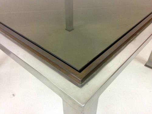 A pair of chrome and brass side tables