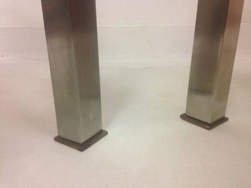 A pair of chrome and brass side tables